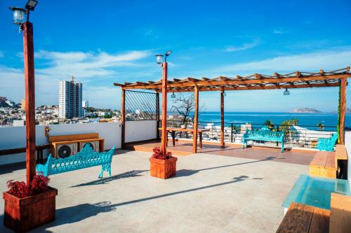 un patio con 2 bancos azules y el océano en Rincon de Liz, en Mazatlán