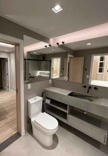a bathroom with a white toilet and a sink at Palácio quitandinha apartamento luxo in Petrópolis