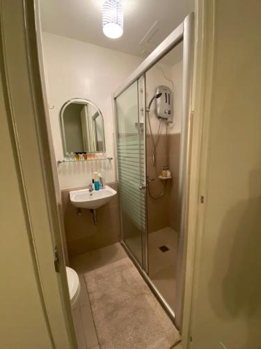 a bathroom with a glass shower and a sink at GZ Studio unit- Camella Northpoint in Davao City