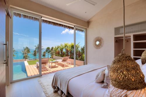 a bedroom with a bed and a balcony with a view at Tropical Seaview Villa with Pool in Koh Samui 