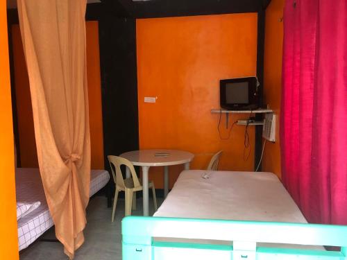 a room with two beds and a table with a tv at El Krimphoff Resort in Romblon