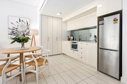 a kitchen with a table and a refrigerator at The Alta Apartments by Urban Rest in Sydney