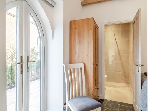 a white room with a chair and a door at Bell House Stables - Uk41789 in Melton Constable