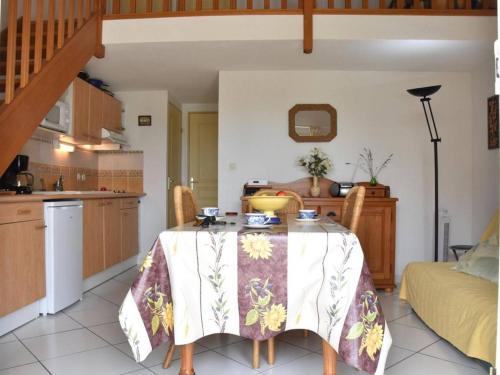 une salle à manger avec une table et une cuisine dans l'établissement Villa cosy avec mezzanine, garage et proche plage - 6 couchages, Gruissan - FR-1-229-834, à Gruissan