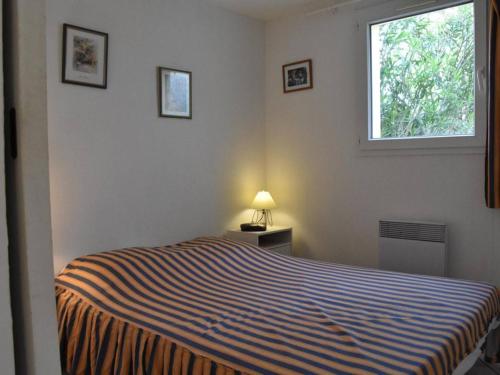 - une chambre avec un lit, une fenêtre et une lampe dans l'établissement Villa cosy avec mezzanine, garage et proche plage - 6 couchages, Gruissan - FR-1-229-834, à Gruissan