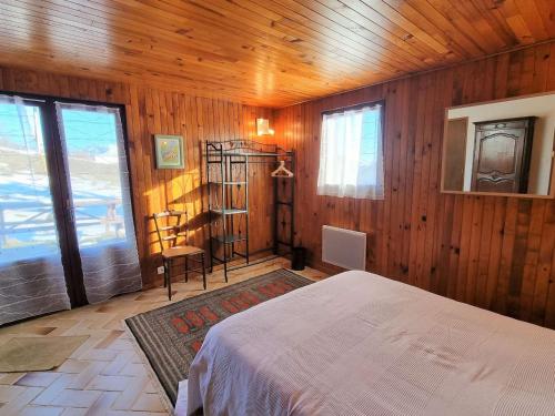 - une chambre avec des murs en bois, un lit et une fenêtre dans l'établissement Spacieux T2 avec Jardin à Proximité du Télésiège – Idéal pour 4 Personnes - FR-1-393-166, à Saint-Michel-de-Chaillol