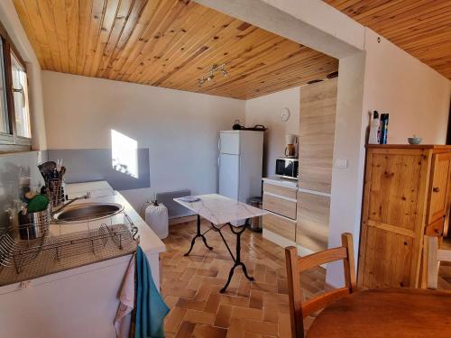 une petite cuisine avec une table et un réfrigérateur dans l'établissement Spacieux T2 avec Jardin à Proximité du Télésiège – Idéal pour 4 Personnes - FR-1-393-166, à Saint-Michel-de-Chaillol
