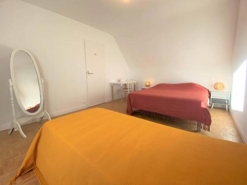a bedroom with two beds and a large mirror at Maison avec Jardin, WIFI, proche plage et commerces, calme - Perros-Guirec - FR-1-368-374 in Perros-Guirec