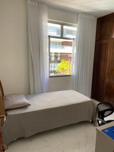 1 dormitorio con cama y ventana en Feriado em Salvador!, en Salvador