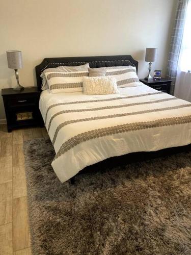 a large bed in a bedroom with two night stands at Very Private 3 Bed Home with HEATED Pool Palms and Big Fenced Yard in Pensacola