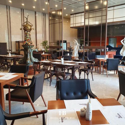 a restaurant with wooden tables and chairs and a cafeteria at Interburgo Hotel Wonju in Wonju