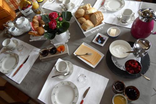 a table topped with plates and bowls of food at B&B Ferme du Petit Breuil in Verviers