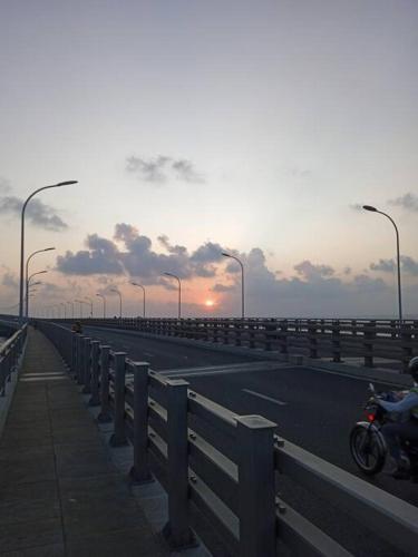 マレにあるfinifenma stay please book if you already in Maldivesの夕日を背景に高速道路のバイク
