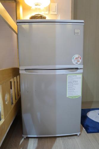 a refrigerator is sitting in a kitchen next to a crib at Andong Poong-gyung HOSTEL n LIBRARY in Andong