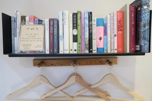 a shelf full of books on a wall at Andong Poong-gyung HOSTEL n LIBRARY in Andong