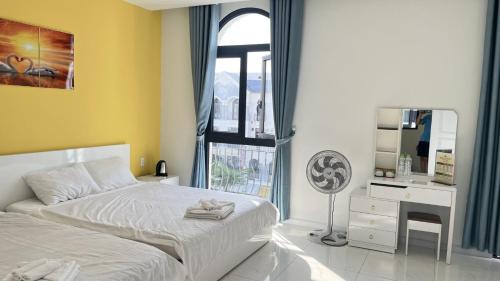 1 dormitorio con cama blanca y ventana en Ngân Hà GrandWorld Phú Quốc, en Phu Quoc