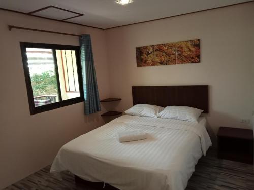 Un dormitorio con una cama blanca y una bandeja. en COWORX Koh Lanta, en Ban Mo Nae