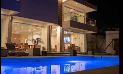 a house with a swimming pool at night at Silver Inn Hotel in Cerro Azul