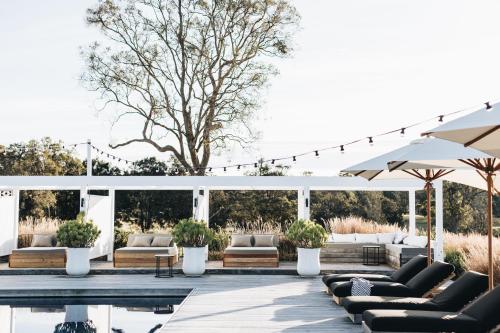 a patio with couches and chairs and a pool at The Oaks Ranch in Tomakin