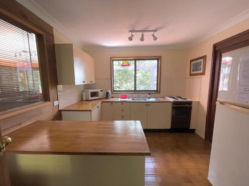 a kitchen with a wooden counter top in a room at Laguna Bungalow in Erowal Bay in Erowal Bay
