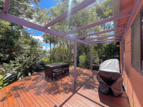 a deck with a bench and a table on a house at Laguna Bungalow in Erowal Bay in Erowal Bay
