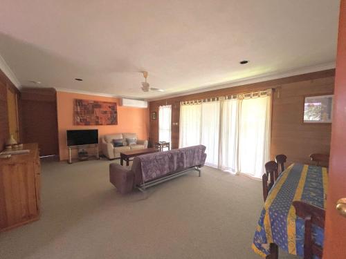 a large living room with a couch and a television at Laguna Bungalow in Erowal Bay in Erowal Bay