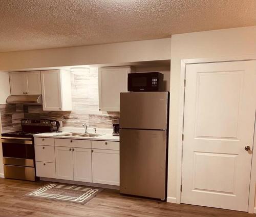 a kitchen with a refrigerator and a sink and a door at North Star Place 7 in Fairbanks