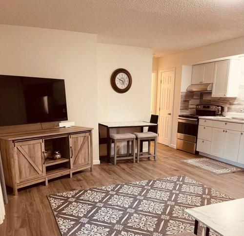 a living room with a television and a kitchen with a table at North Star Place 7 in Fairbanks