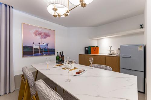 a dining room with a table with chairs and a refrigerator at Brown Dot Hotel Cheonan Buldang in Cheonan