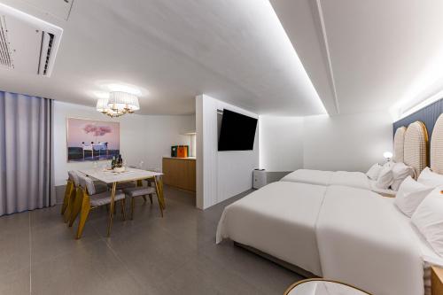 a white bedroom with a bed and a dining room at Brown Dot Hotel Cheonan Buldang in Cheonan