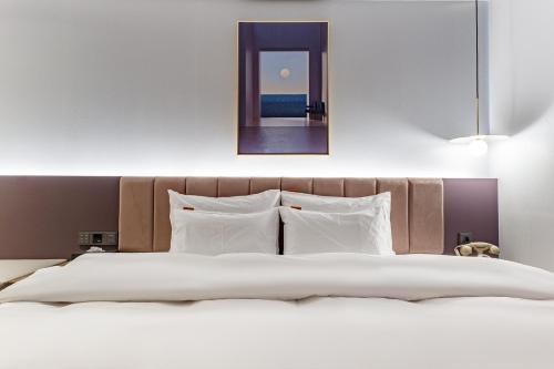 a bedroom with a large bed with a mirror above it at Brown Dot Hotel Cheonan Buldang in Cheonan