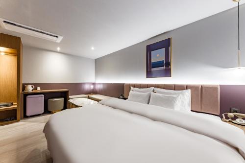 a hotel room with a large bed and a tv at Brown Dot Hotel Cheonan Buldang in Cheonan