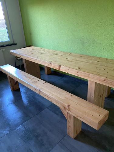 een houten tafel en bank in een kamer bij MZ Zimmervermietung 