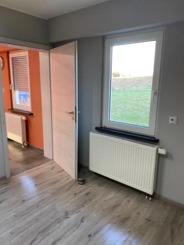 een lege kamer met een raam en een deur bij MZ Zimmervermietung 