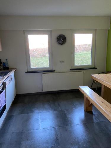 een keuken met twee ramen en een houten tafel bij MZ Zimmervermietung 
