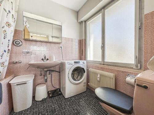 a bathroom with a washing machine and a sink at Between slopes and golf facing the Alps in Crans-Montana