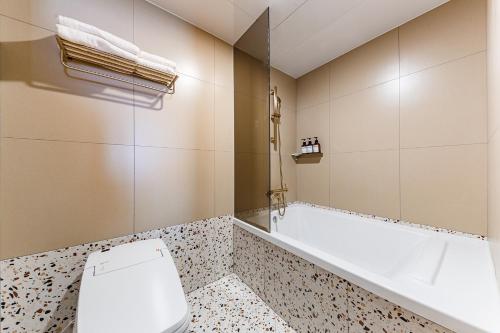 a bathroom with a toilet and a bath tub at Brown Dot Hotel Cheonan Buldang in Cheonan