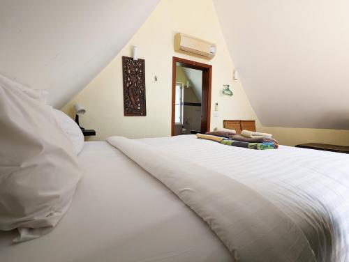 a large white bed in a room with a window at Blue Sky Pool Villa in Trat