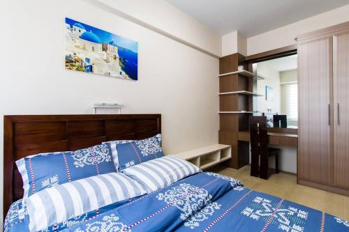 a bedroom with a bed with blue and white pillows at 2 BR Condo Apartment near NAIA 3 Pasay City in Manila