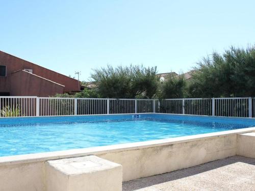 une grande piscine entourée d'une clôture. dans l'établissement Pavillon 3 pièces avec mezzanine, piscine, proche plage du Grazel - 5 couchages, parking, véranda - FR-1-229-72, à Gruissan