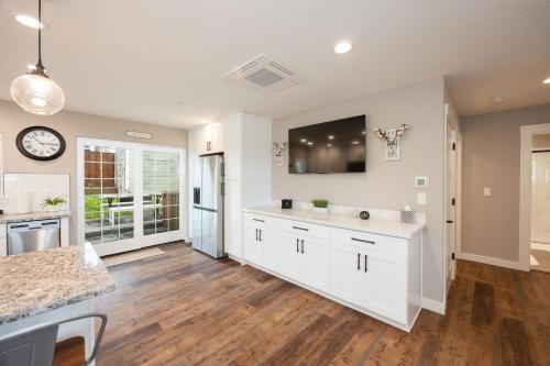 a kitchen with white cabinets and a clock on the wall at Montara Beach Mountain Escape in Montara