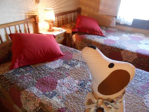 a bedroom with two beds with red pillows at Masia Can Constans in Queralbs