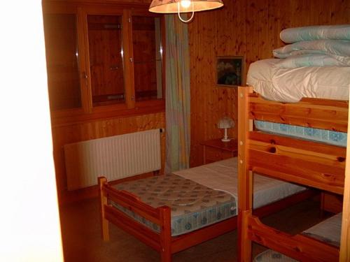 ein Schlafzimmer mit einem Etagenbett und einem Stuhl in der Unterkunft Chalet Solina in Icogne