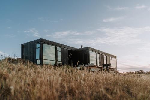 a black house on a hill in a field at Wander on Kangaroo Island in Stokes Bay