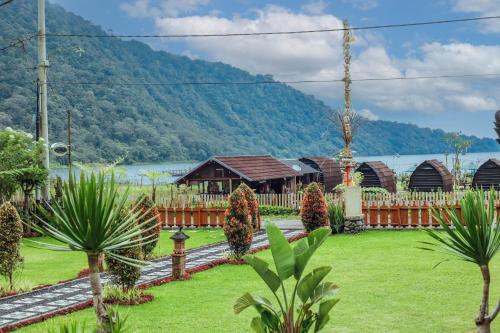 a resort with a lake and mountains in the background at The Polumb Garden Bedugul in Tabanan