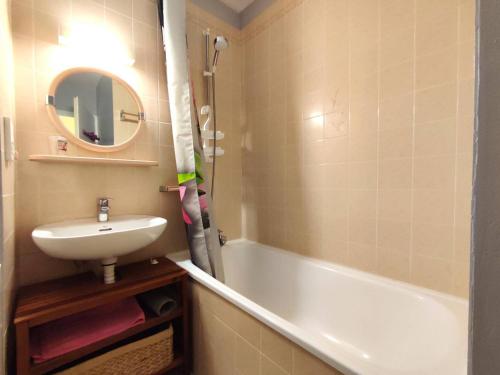 une salle de bain avec un lavabo et une baignoire dans l'établissement Appartement 3* avec balcon et parking face à la plage de Trégastel - FR-1-368-171, à Trégastel