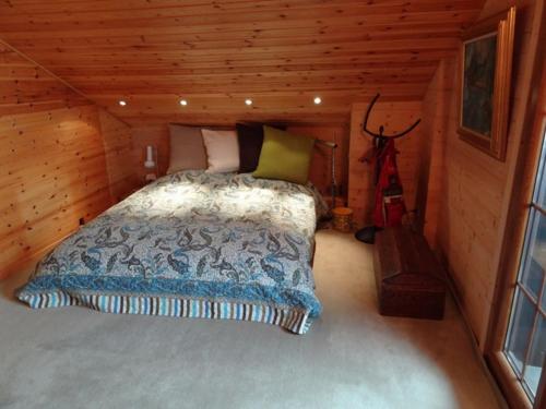 a bedroom with a bed in a log cabin at Chalet le Rhône in Mollens