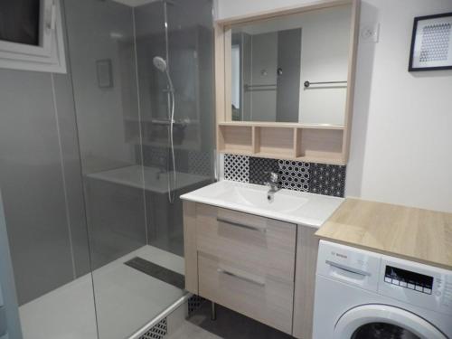 une salle de bain avec douche et lavabo et une machine à laver dans l'établissement Appartement 3 pièces rénové, proche plage et commerces, pour 4 personnes - FR-1-326-669, à Marseillan