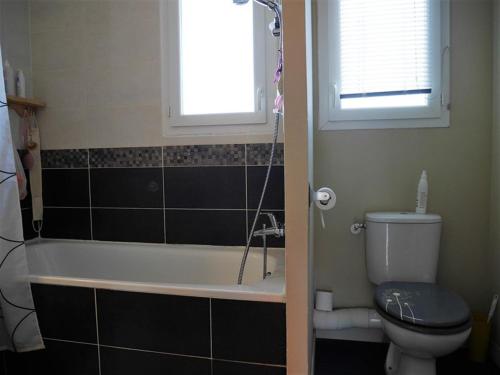 une salle de bain avec baignoire et toilettes et une fenêtre dans l'établissement Maison à Capbreton avec Jardin, Proche Plage, WiFi et Parking - FR-1-413-86, à Capbreton