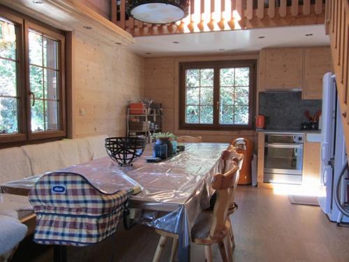 a kitchen with a table and chairs in a room at Chalet le Rhône in Mollens